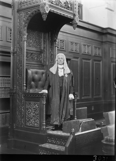 Royal Visit, May 1927. Sir Littleton Groom standing at the Speaker's Chair, House of Representatives Chamber.
