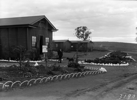 Workmen's huts with extensive garden beds. The Mess.