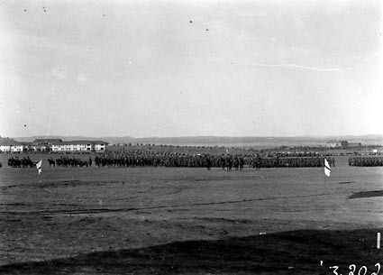 Artillery, cavalry and infantry on parade at the Royal Review after the opening of Parliament House, Hotel Kurrajong in the background
