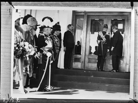 Duke of York opening the front door of Parliament House, Prime Minister Rt Hon Stanley Bruce on the left, Governor General on right.