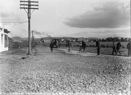 Mort Street, Braddon, South from Canberra Times Office. Road making with manpower, Civic Centre buildings in background.
