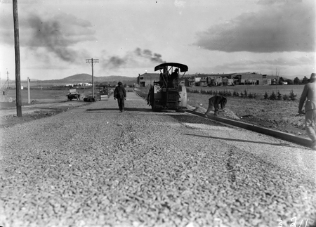 Steamroller at work in Mort Street, Canberra City with Civic Centre buildings in background.