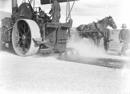 Steamroller fitted with tar spray at work, Mort Street, Canberra City. Horse and dray.