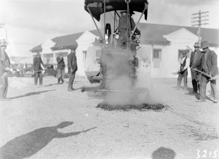 Steamroller at work near Canberra Times office with road workers spreading gravel.