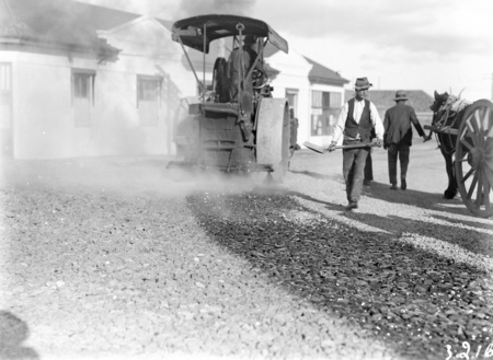 Steamroller spraying tar near Canberra Times office with roadworkers and dray.
