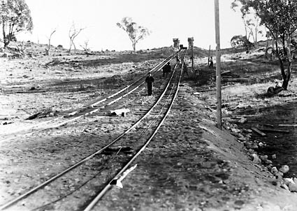 Narrow gauge railway lines used for hauling broken rock to crushing plant.Note downhill run for  the skips and hauled uphill by the cable between the tracks
