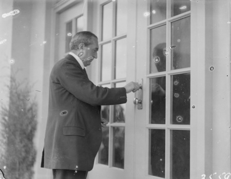 The Right Honorable Stanley Melbourne Bruce opening the front door of Ainslie School in September 1927.