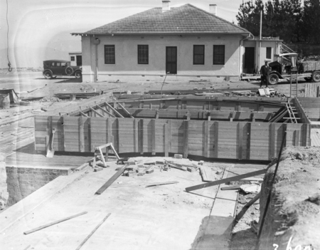 Construction site, Mount Stromlo with finished building, car and truck in the background.