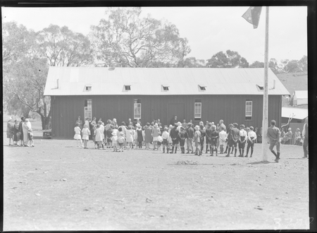 School building with children and crowd at the opening of Mount Russell School.