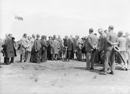 Part of crowd with Rt Hon S M Bruce on shovel.