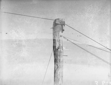 Power pole with guy ropes at the top.