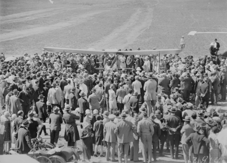 Crowd welcoming Captain W.N. Lancaster and Mrs Keith Miller and their Avro Avian aircraft G-EBIO at the Review Ground opposite Hotel Kurrajong.