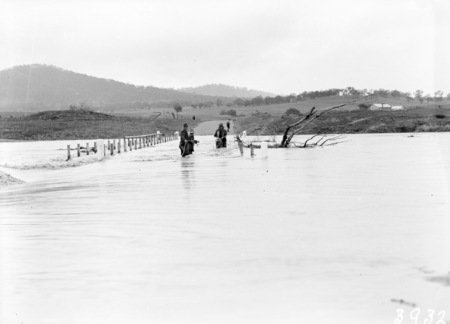 Floodwaters at Scotts Crossing. Workmen removing bridge rails and flood debris.
