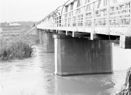 Commonwealth Bridge over the Monoglo River showing floodwaters and depth gauge.
