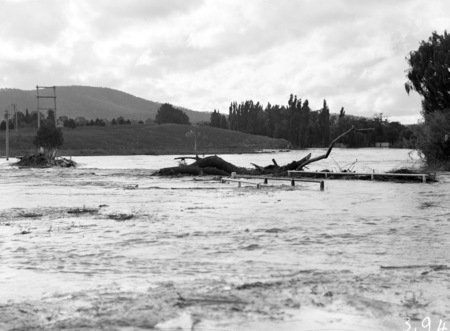 Floodwaters at Acton Crossing. Flood debris on the bridge.