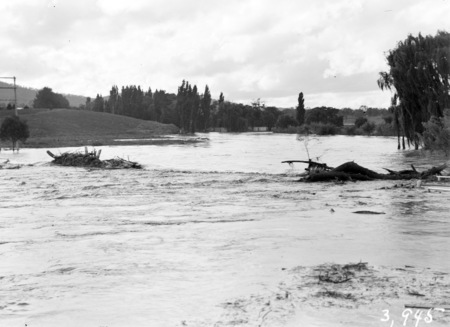 Floodwaters at Acton Crossing. Flood debris on the bridge.