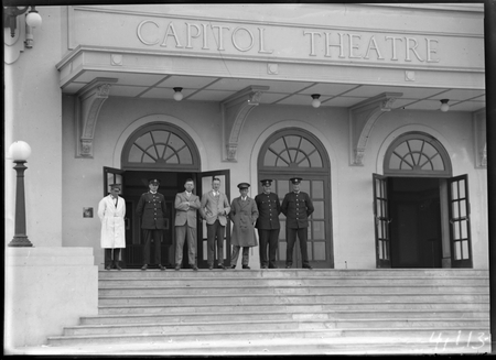 Policeman, bus drivers and civilians on steps of Capitol Theatre, Manuka, for Empire Day celebrations.