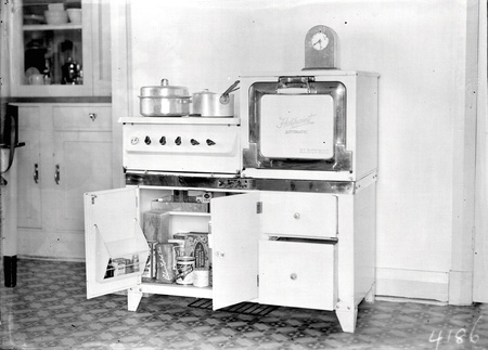 Hotpoint Electric stove with cooking pots etc. in the cupboard beneath