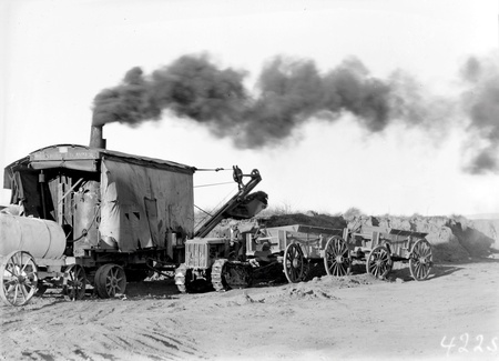 Keystone steam shovel loading wagons hauled by a Cletrac Tractor