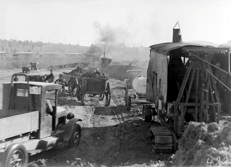 Keystone steam shovel and tractor towing two loaded  wagons and a motor truck