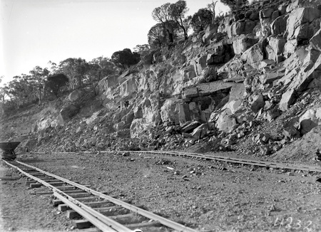 Quarry face with narrow gauge  tram  tracks and a skip