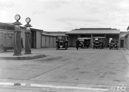 Buses and motor car at Kingston  depot with petrol pumps