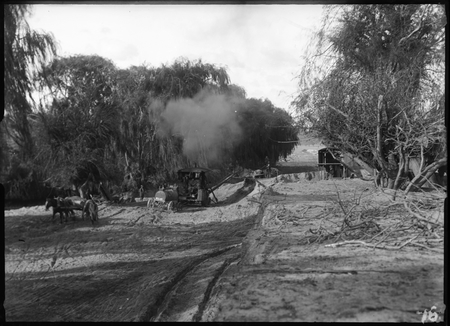 Steam shovel loading sand onto horse drawn drays.