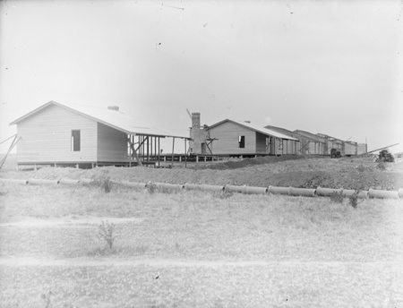 Weatherboard cottages under construction.