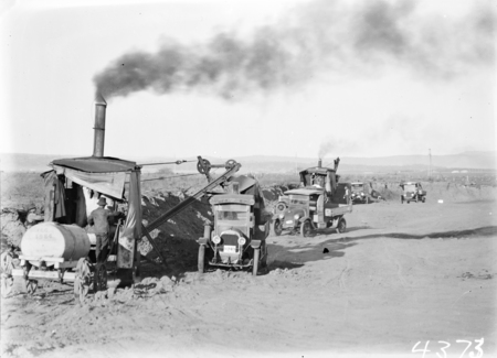 Two Keystone steam excavators loading motor trucks.