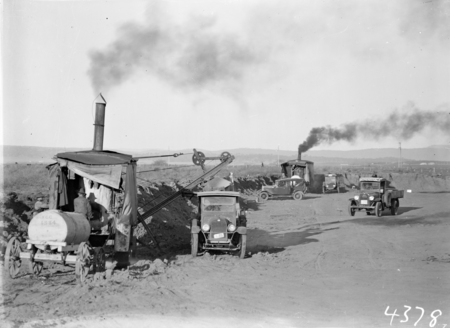 Two Keystone steam excavators loading motor trucks.