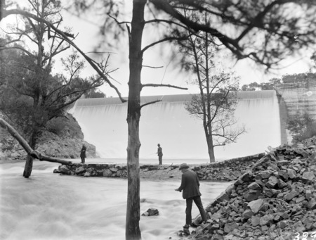Cotter Dam spillway and stilling pond with three trout fishermen.