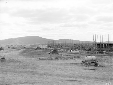 Parliament House in early stages of construction showing Hotel Canberra on the left.