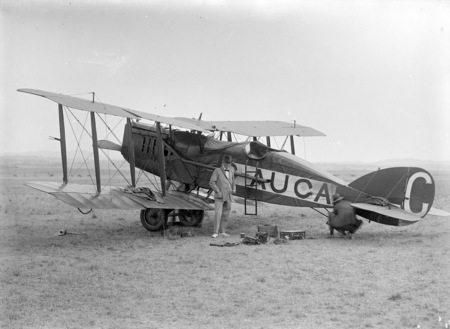 Biplane (G-AUCA) with two people.
