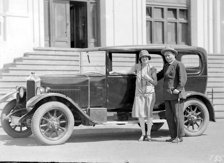 Mr and Mrs Deane with motor car, in front of Parliament House