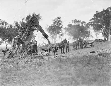 Barber Greene Ditch Digger loading horse drawn drays.