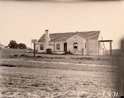 House with sign: LH Rudd Architect