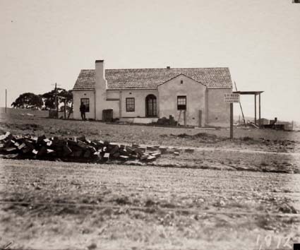 House with sign: LH Rudd Architect