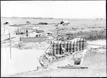 Scotts Crossing over the Molonglo River under construction looking south showing Molonglo camp and Blundells Cottage.