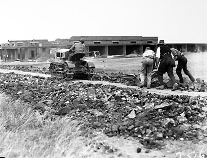 Cletrac crawler tractor pulling plough for road making near Kingston shops