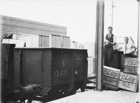 First consignment of liquor following the lifting of Probition in the ACT. Railway  truck load of beer cases being unloaded and the tally clerk.
