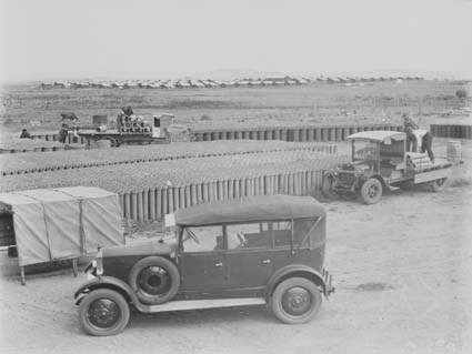Concrete pipes in Kingston storage yard with motor trucks being loaded and Mildenhall's Armstrong Siddeley motor car