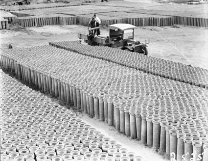 Concrete pipes in Kingston storage yard with a motor truck being loaded