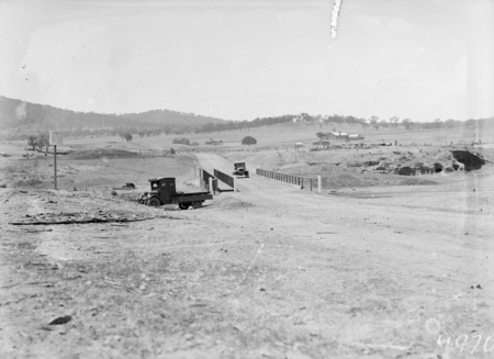 Scotts Crossing over the Molonglo River, showing Blundell's Cottage in the background, Chevrolet motor truck in the foreground and another vehicle on the bridge.