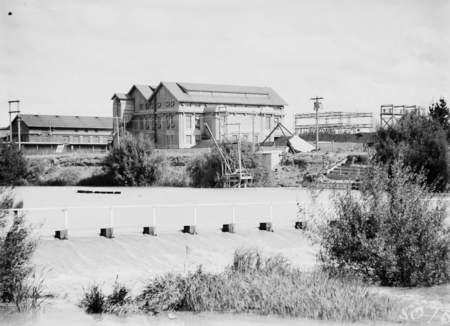 Buildings. Electricity ACT Kingston Power Station from weir on the Molonglo River(in flood) Note; tiers of seats to the right for swimming sports spectators when the weir was used as a swimming pool.