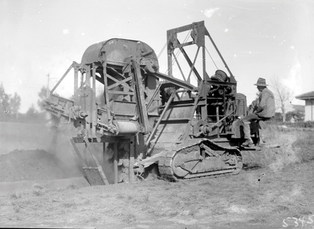 Ditch digger excavating a drainage trench