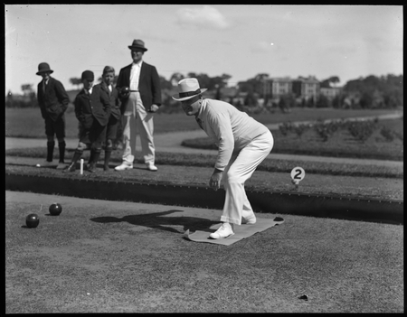 Game of bowls in progress at Hotel Canberra with HR Waterman looking on and West Block in the background.