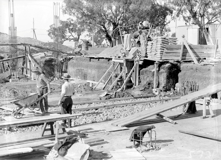 Workmen engaged on Australian Institute of Anatomy foundations showing concrete mixers.