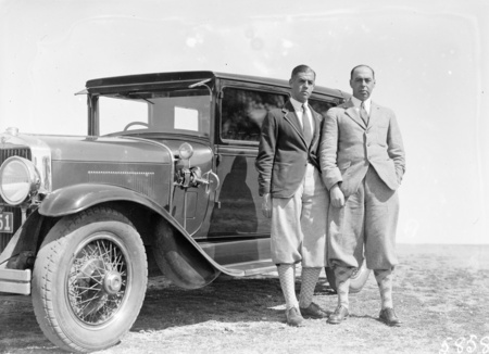 Two golfers with motor car.