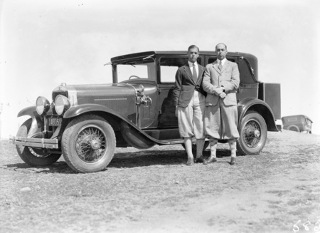 Two golfers with a motor car.