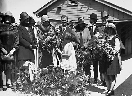 Mrs Scullin being presented with flower bouquets by children on Canberra railway station